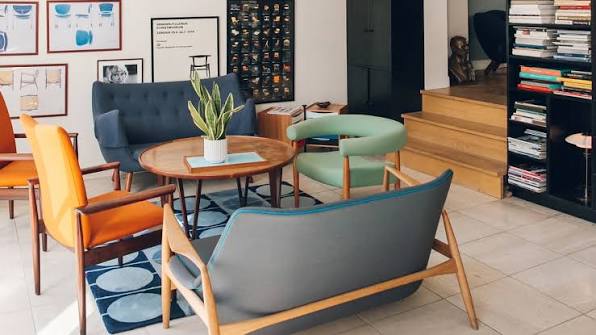 A lobby furnished with mid-century Danish chairs, lamps and cabinets
