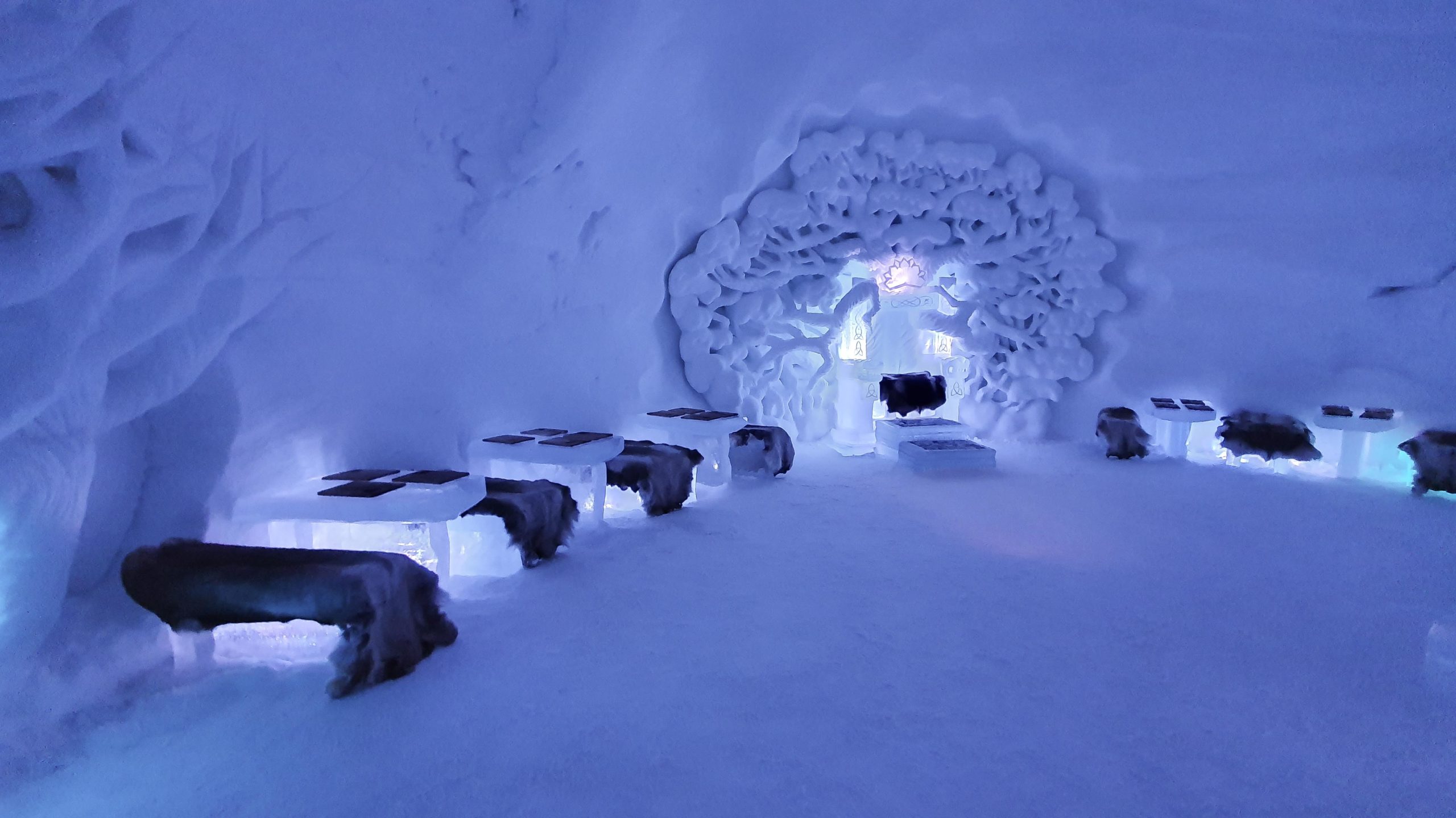 Rounded snow domes standing on a valley floor under a low winter sky